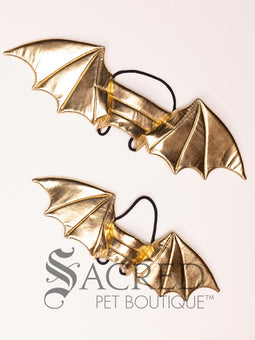The Small size black bat costume wings sit on a white background. A loop at the top goes over the dogs head allowing the wings to sit over the dogs shoulders or wherever you think it looks best. The tails of the loop allow the head loop to be pulled longer or shorter and can then be tied under the dogs belly, or around its harness.