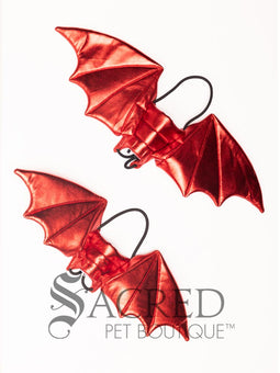 The Small size black bat costume wings sit on a white background. A loop at the top goes over the dogs head allowing the wings to sit over the dogs shoulders or wherever you think it looks best. The tails of the loop allow the head loop to be pulled longer or shorter and can then be tied under the dogs belly, or around its harness.