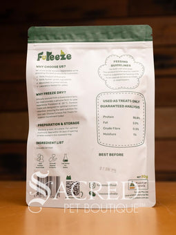 A packet of Freeze dried Australian crocodile tail meat sits on a wooden table with a wood plank background. A clear window in the pack shows the pieces to be approximately 2cm pieces.
