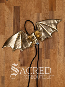 The Small size black bat costume wings sit on a white background. A loop at the top goes over the dogs head allowing the wings to sit over the dogs shoulders or wherever you think it looks best. The tails of the loop allow the head loop to be pulled longer or shorter and can then be tied under the dogs belly, or around its harness.