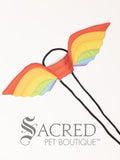 The small size gold rainbow pattern wings sit on a white background. A loop at the top goes over the dogs head allowing the wings to sit over the dogs shoulders or wherever you think it looks best. The tails of the loop allow the head loop to be pulled longer or shorter and can then be tied under the dogs belly, or around its harness.