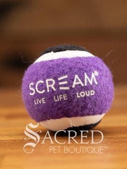 A single blue and orange tennis ball sits on a wooden table with a wooden background. The ball is solid foam, so it won't pop, has dog friendly fuzz and does not squeak.