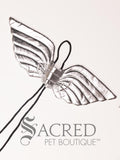 The Large size silver angel costume wings sit on a white background. A loop at the top goes over the dogs head allowing the wings to sit over the dogs shoulders or wherever you think it looks best. The tails of the loop allow the head loop to be pulled longer or shorter and can then be tied under the dogs belly, or around its harness.