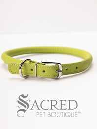 A black, round, soft leather dog collar with a metal buckle clasp. Our beautiful Soft Round (Rolled) leather collars are highly recommended for long haired dogs. Round or rolled collars reduce the amount of matting, tangling and flattening of the dogs fur. All collars are hand made and stitched with wax thread, from the finest quality soft leather wrapped and stitched around a nylon inner cord for added strength.Image on a white background, with the Sacred Pet Boutique logo.