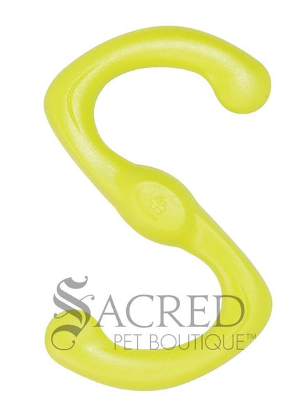 A bright green dog toy in a distinctive S shape and has a slightly textured, matte finish and includes a small circular emblem stamped in the centre with a dog paw print. It's lying on a white background with a grey Sacred Pet Boutique watermark at the bottom of the image.