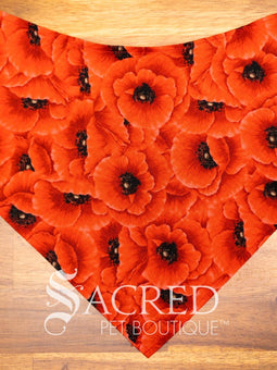 Dog wearing a purple poppy patterned ANZAC memorial bandana with 'Sacred Pet Boutique' logo.