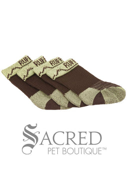 The owner is sitting in the back of a car. His Doberman dog has a full set of Bark'n'Boot liners on and is having his first boot fitted. The dog is patiently watching what the owner is doing.