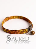 Cat collar with colourful rich chocolate pattern with matching clip and bell on a white background, branded as Sacred Pet Boutique.