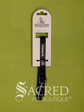 A black Catventure cat leash with a metal clasp, hanging from its white cardboard retail hanger against a solid olive green background. A 'Sacred Pet Boutique' watermark is visible at the bottom.