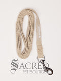 The Catventure logo is shown on the beige leash near the stainless steel snap hook end of the leash. The leash is shown looped and on a white background. There is a D-Ring at the handle for attaching poo bags.