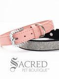 A pink and black faux suede dog collars with sparkling rhinestone accents and a rhinestone-encrusted buckle on white background and Sacred Pet Boutique watermark.