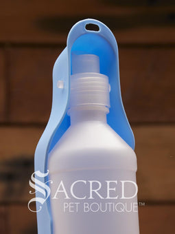 Pet water bowl with bottle attachment on a wooden surface, branded 'Sacred Pet Boutique'.