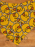 A yellow duck patterned dog bandana spread flat on wooden table and with a white Sacred Pet Boutique watermark 