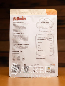 Freeze dried wallaby pieces can be seen through a clear window in the orange packaging of the Fureeze brand of products. The pack sits on a wooden table with a wood plank background.