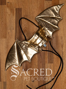 The Small size black bat costume wings sit on a white background. A loop at the top goes over the dogs head allowing the wings to sit over the dogs shoulders or wherever you think it looks best. The tails of the loop allow the head loop to be pulled longer or shorter and can then be tied under the dogs belly, or around its harness. 