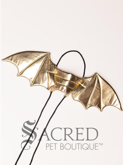 The Small size black bat costume wings sit on a white background. A loop at the top goes over the dogs head allowing the wings to sit over the dogs shoulders or wherever you think it looks best. The tails of the loop allow the head loop to be pulled longer or shorter and can then be tied under the dogs belly, or around its harness. 