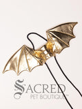 The small size gold dragon costume wings sit on a white background. A loop at the top goes over the dogs head allowing the wings to sit over the dogs shoulders or wherever you think it looks best. The tails of the loop allow the head loop to be pulled longer or shorter and can then be tied under the dogs belly, or around its harness. 