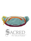 Teal bum bag dog pack with orange zipper and yellow highlights with a burgundy base on a white background, featuring the Ruffwear brand.