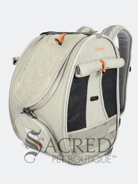 Person carrying a pet carrier with a cat inside, with a dog. surrounded by greenery, featuring the watermark 'Sacred Pet Boutique'.