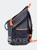 A dark navy fabric and black mesh pet backpack with bright orange accents, shown from a three-quarter angle against a light grey background. The brand name 'SACRED PET BOUTIQUE' is watermarked across the bottom.