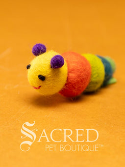 A pile of colourful wool felt balls with polka dots sits on a wooden table. Suitable for all cats and small to teacup sized dogs.