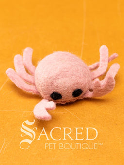 A pile of colourful wool felt balls with polka dots sits on a wooden table. Suitable for all cats and small to teacup sized dogs.