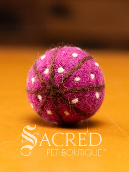 A pile of colourful wool felt balls with polka dots sits on a wooden table. Suitable for all cats and small to teacup sized dogs.