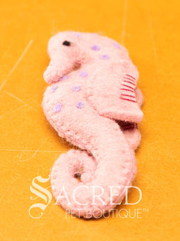 A pile of colourful wool felt balls with polka dots sits on a wooden table. Suitable for all cats and small to teacup sized dogs.