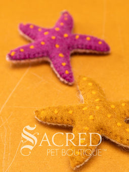 A pile of colourful wool felt balls with polka dots sits on a wooden table. Suitable for all cats and small to teacup sized dogs.