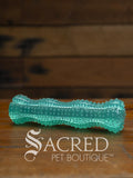 Blue green KONG Squeeze textured dog dental toy on a wooden surface with 'Sacred Pet Boutique' branding.