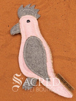 Kevin the Koala is a jute dog toy with wool felt detail and multiple rows of stitching, on a wooden background. A white Sacred Pet Boutique watermark.