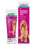 A tube and box of paw Manuka Wound Gel shown on a white background, featuring a golden retriever on the packaging. A 'SACRED PET BOUTIQUE' watermark is visible at the bottom.