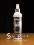 A 250ml bottle of Petway Coat Shine Spray for pets, featuring a white bottle with a silver spray nozzle and a silver black label, set against a dark background on a wooden surface. With a white Sacred Pet Boutique watermark.
