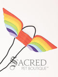 The large size rainbow pattern costume wings sit on a white background. A loop at the top goes over the dogs head allowing the wings to sit over the dogs shoulders or wherever you think it looks best. The tails of the loop allow the head loop to be pulled longer or shorter and can then be tied under the dogs belly, or around its harness. 