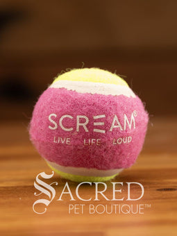 A single blue and orange tennis ball sits on a wooden table with a wooden background. The ball is solid foam, so it won't pop, has dog friendly fuzz and does not squeak.