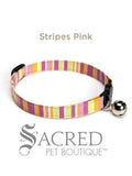 An pink white yellow lime green striped soft fabric cat collar with black plastic hardware and a silver bell with a safety breakaway buckle on a white background. A Sacred Pet Boutique watermark