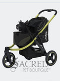 A black pet stroller with a lime green frame, shown with a small black dog sitting inside. The stroller is photographed on a white background with a 'Sacred Pet Boutique' watermark at the bottom.