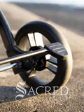 Close-up of a pet stroller wheel and brake with 'Sacred Pet Boutique' logo.