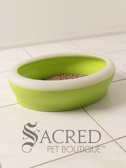 A beautiful white chinchilla persian cat is shown using a dark pink Vicci litter tray in a white room on a white tiled floor.