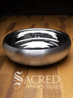 A beautifully styled curved sided double walled steel bowl with brand name ZEEZ etched on the outer brushed finished edge shows the highly polished inner where the brand name is embossed on the base.
