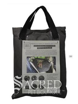 A golden labradoodle sits on the hammock in the back seat of a modern car with a cream leather interior. The Waterproof Hammock car seat cover is definitely protecting the car seat and stopping the dog from falling into the foot well.