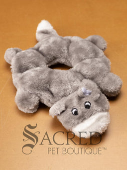 A plush dog toy resembling a wolf in a neutral grey colour, placed on a flat surface, with the brand 'Sacred Pet Boutique' visible.