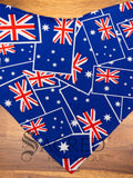 An Australian Flag dog bandana spread flat on wooden table and with a grey Sacred Pet Boutique watermark