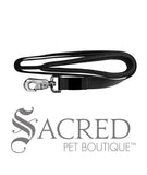 A black padded handle 183cm long leash with a heavy duty metal snap clip. With our comfort leashes, you'll feel less fatigued and be able to focus on enjoying your walk rather than the pain in your hands. Image on white background and 'SACRED PET BOUTIQUE' watermark.